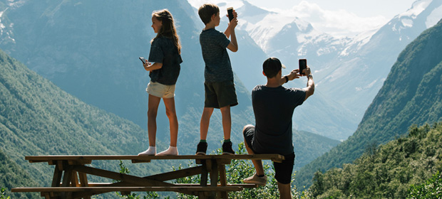 familie på tur på fjellet og tar bilder med mobil