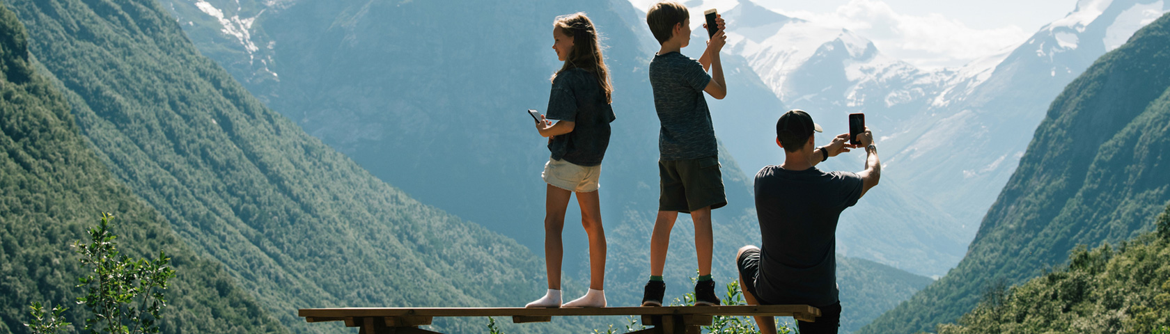 Familie på tur i fjellet og tar bilder med mobil