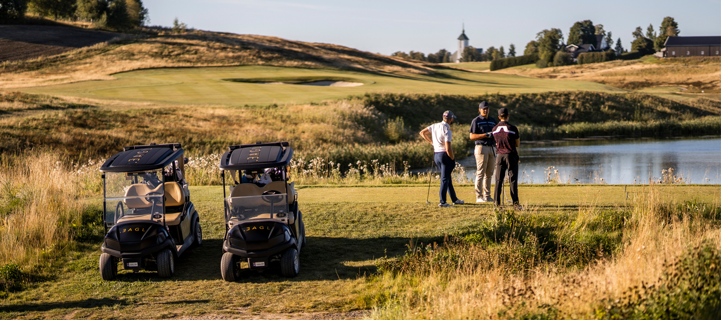 Golfbane med golfbiler og golfspillere. 