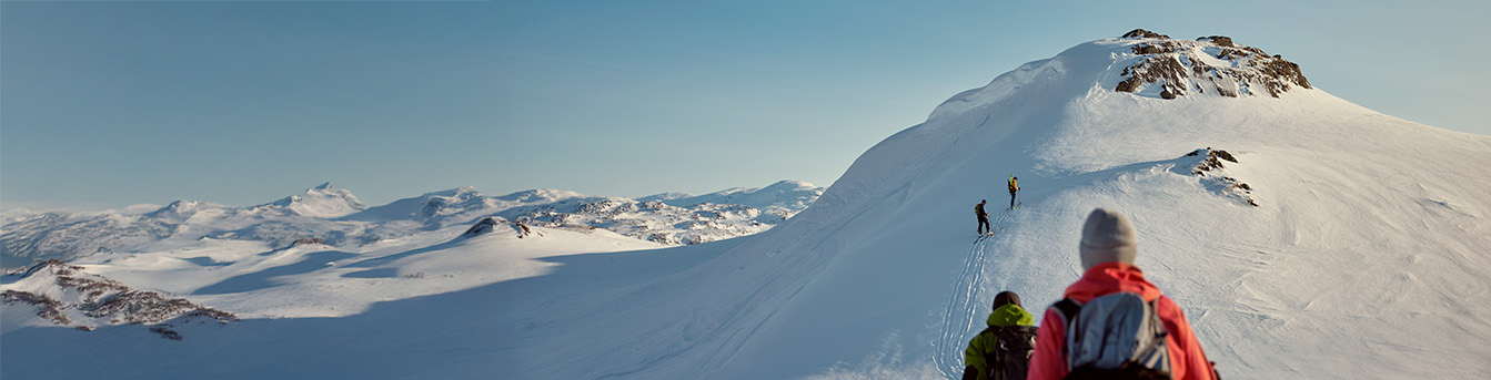 Turgåere i fjellet, vinter og snø, med blå himmel