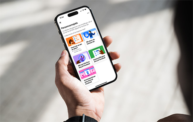 Hånd holder en mobil med personverninnstillinger på skjermen